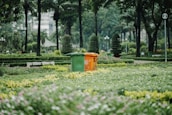 Clean city park with trash bins and people enjoying the green space.