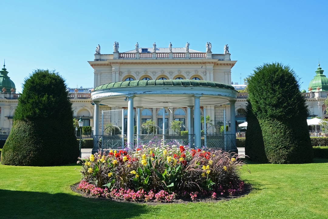 white concrete building with flowers on the garden