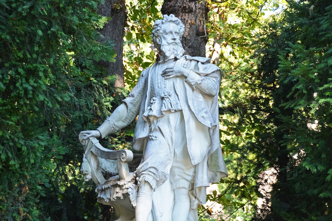 angel statue near green trees during daytime