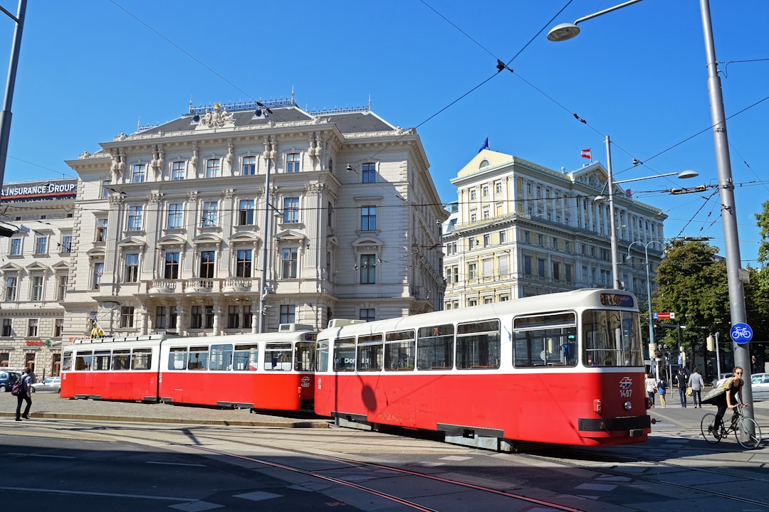 red and white tram on road near white concrete building during daytime