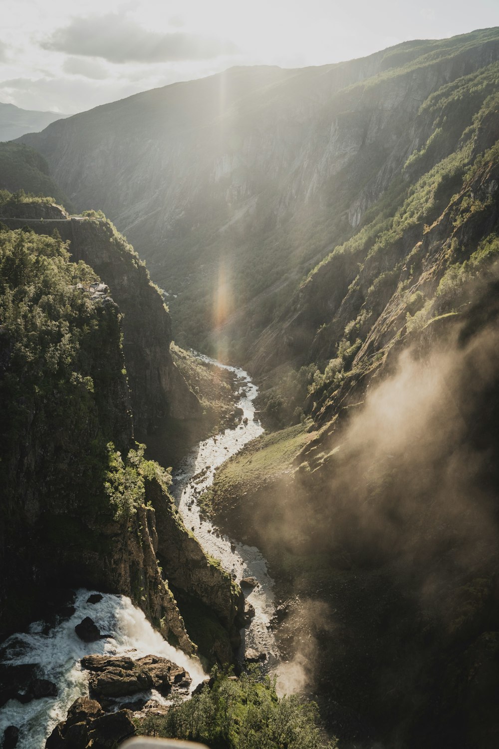 river between green mountains during daytime