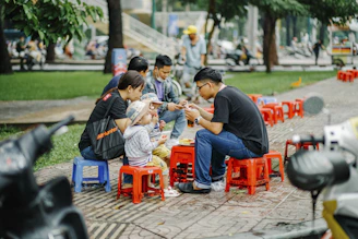 a group of people sitting around a red table