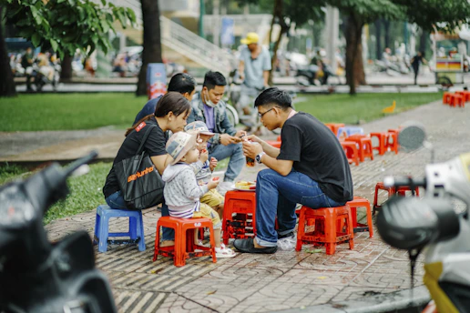 a group of people sitting around a red table