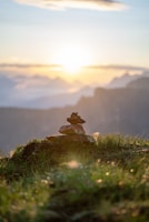 Close-up of a balanced stone stack casting long shadows on a misty morning.