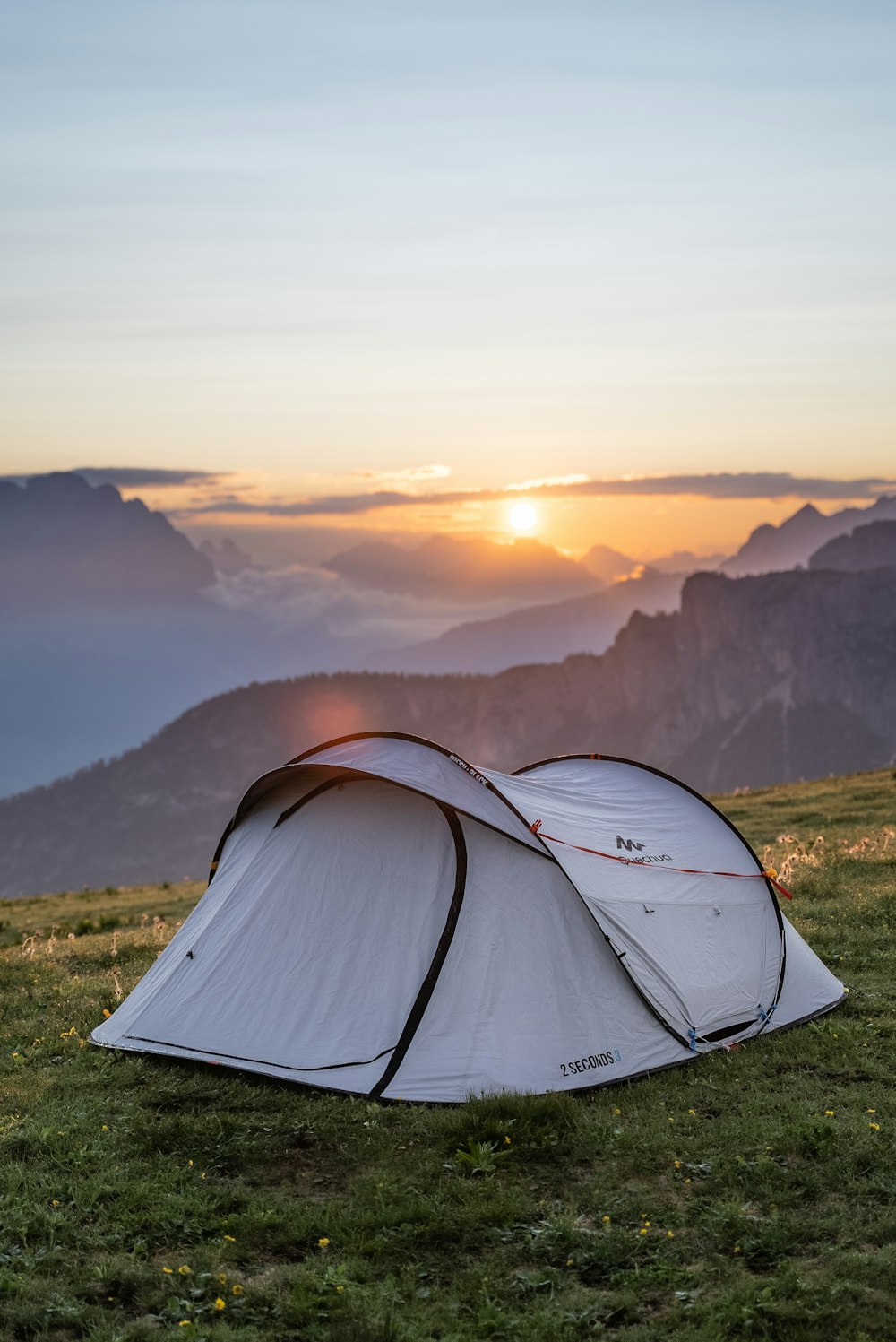 Weißes Zelt auf grünem Grasfeld bei Sonnenuntergang