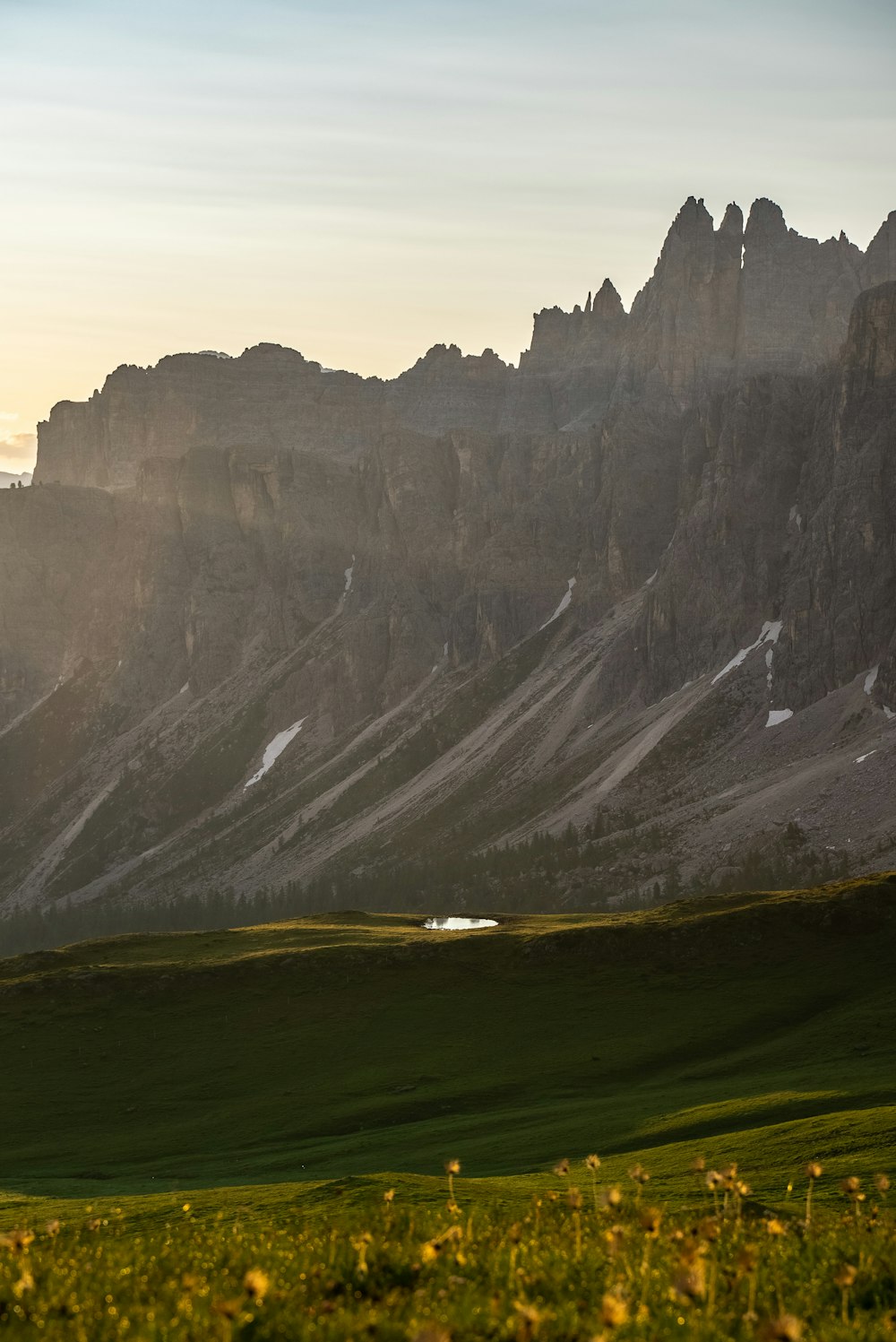 green grass field near rocky mountain during daytime