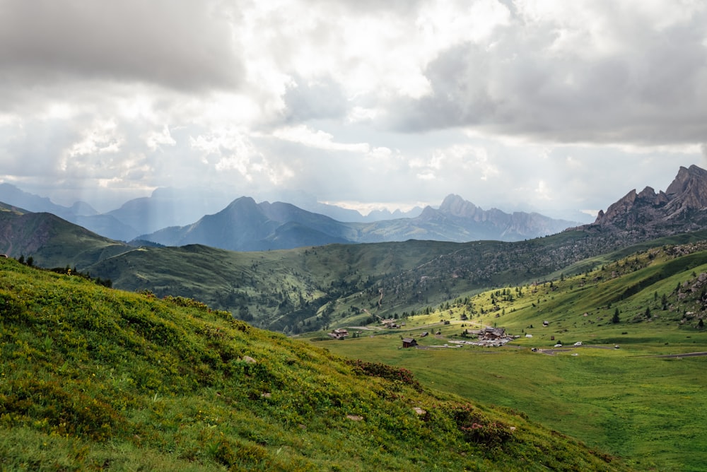 Champ d’herbe verte et montagnes sous les nuages blancs