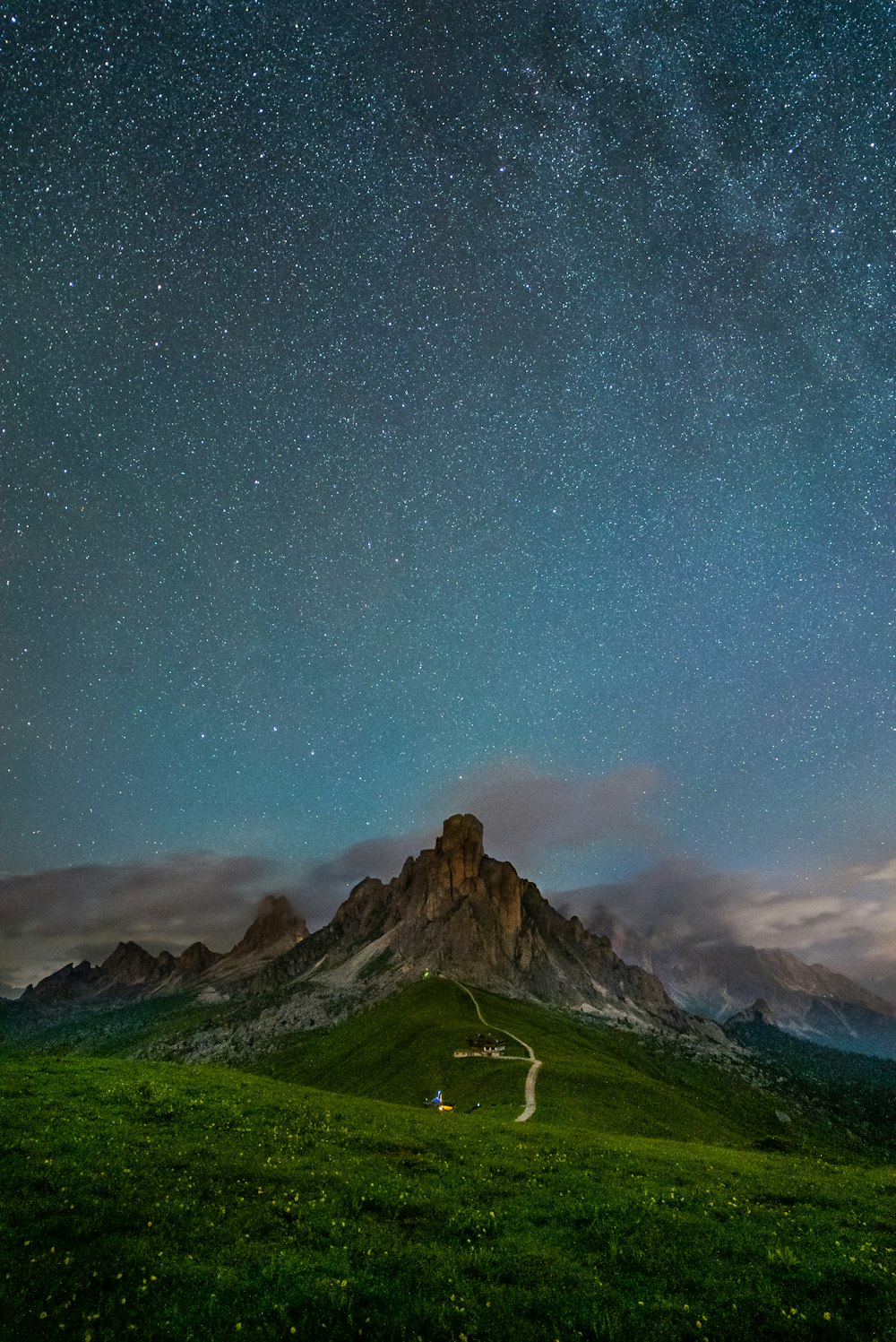 Champ d’herbe verte et montagne sous la nuit étoilée