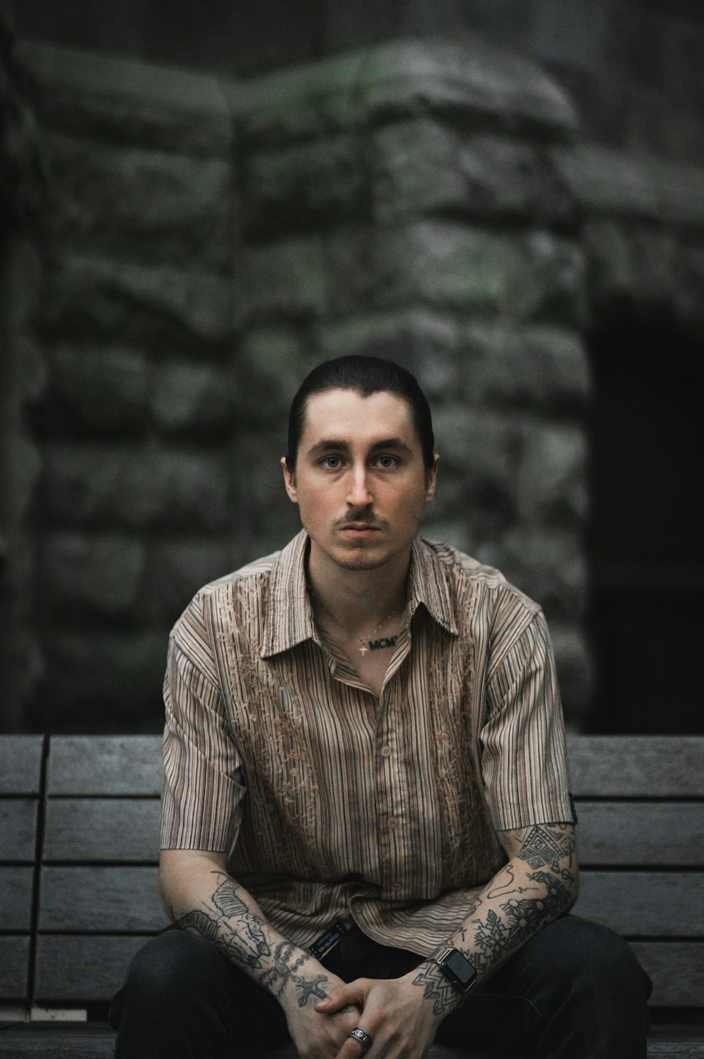 a man sitting on top of a wooden bench