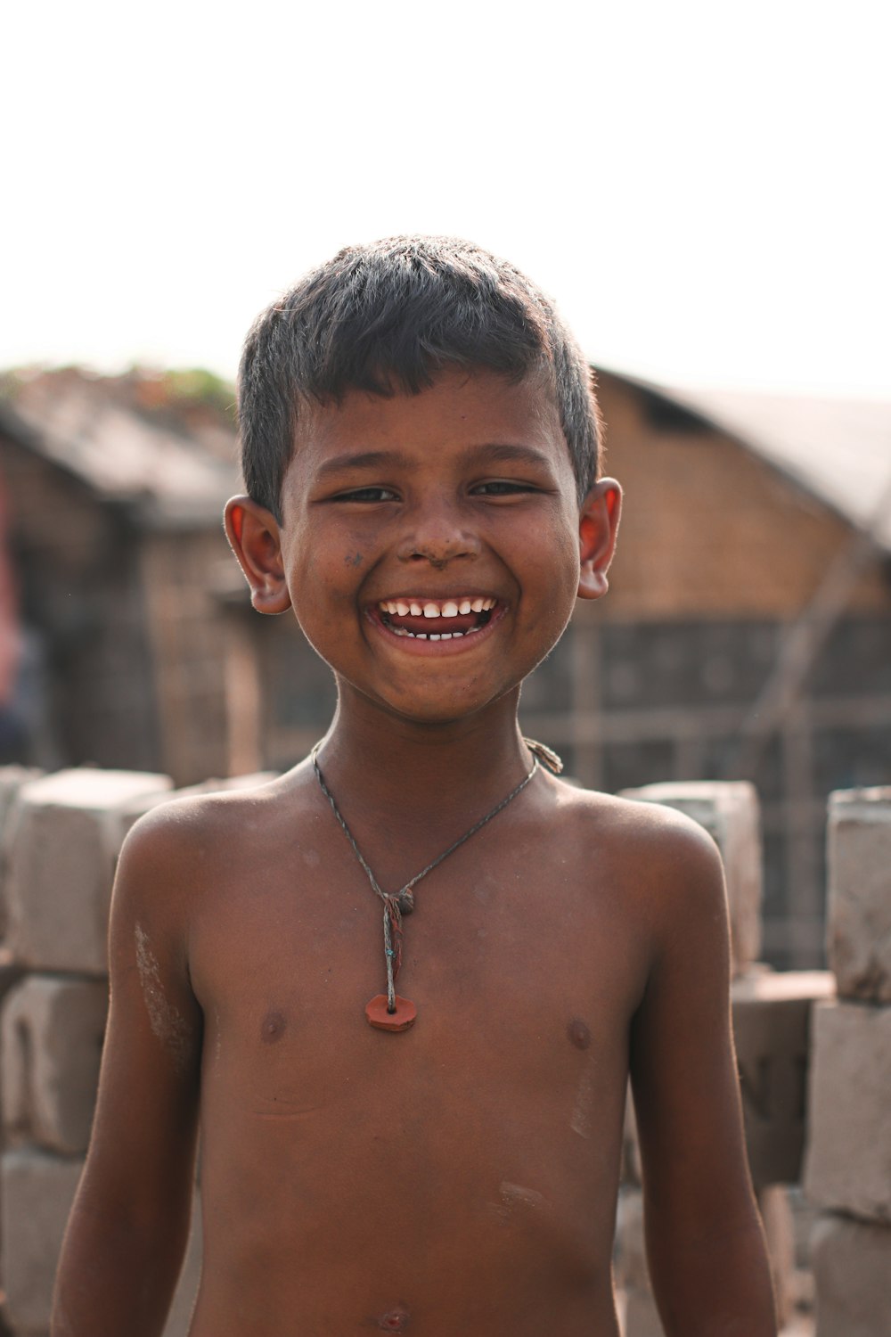 topless boy smiling during daytime