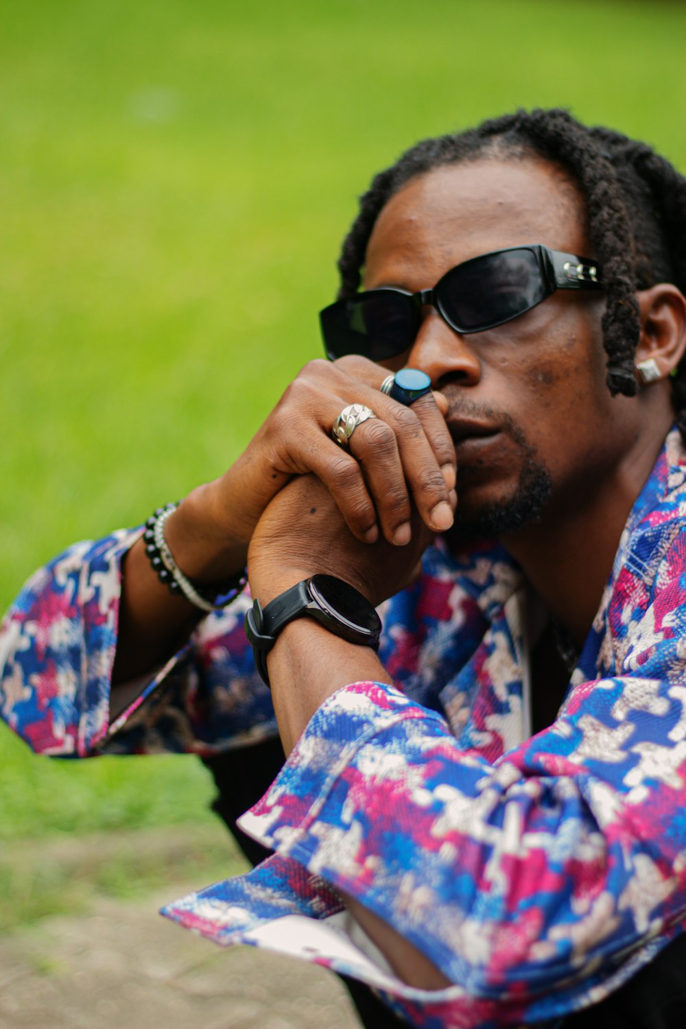 man in blue and red floral button up shirt wearing black sunglasses