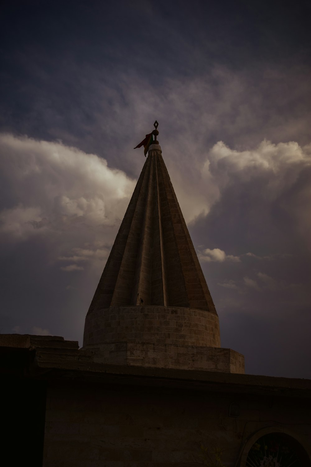 man in black jacket standing on top of gray concrete tower under cloudy sky during daytime