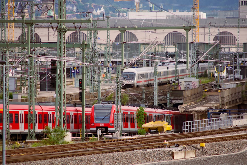 rot-weißer Zug tagsüber auf Bahngleisen