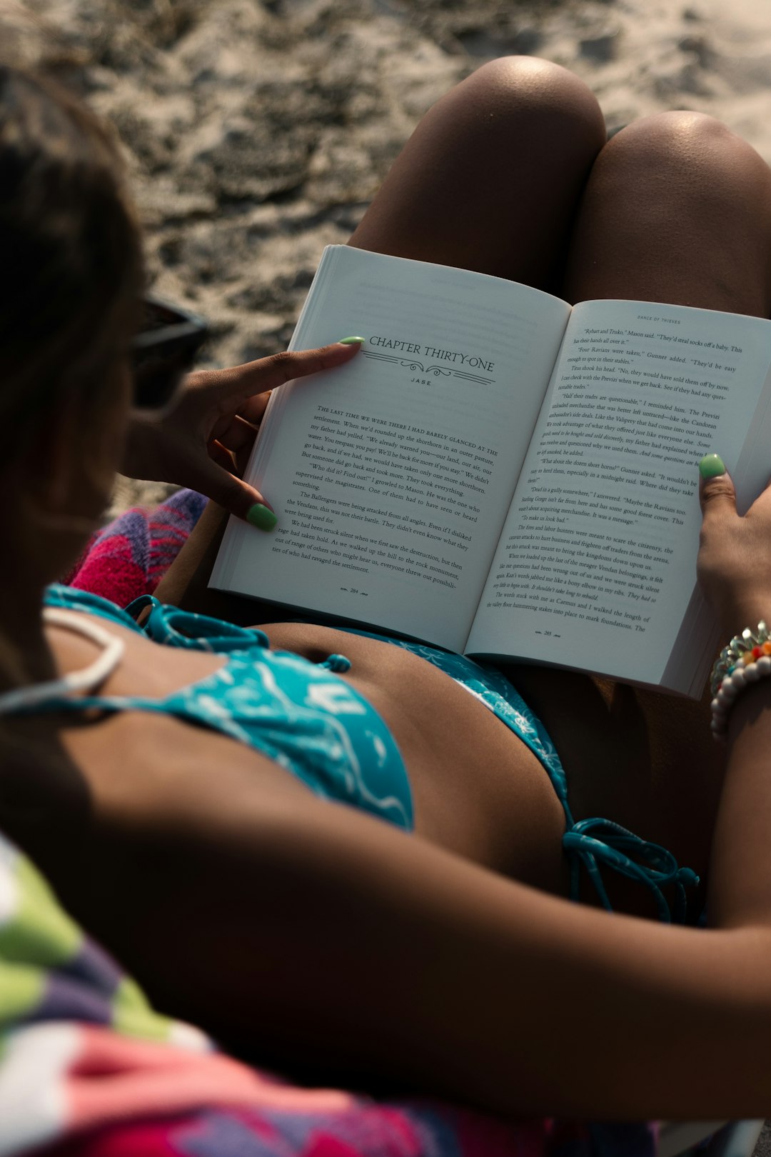 woman in blue bikini reading book