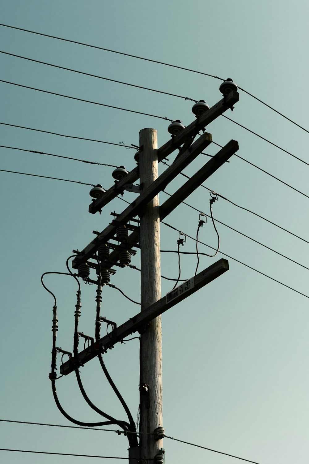 palo elettrico in legno marrone sotto il cielo blu durante il giorno
