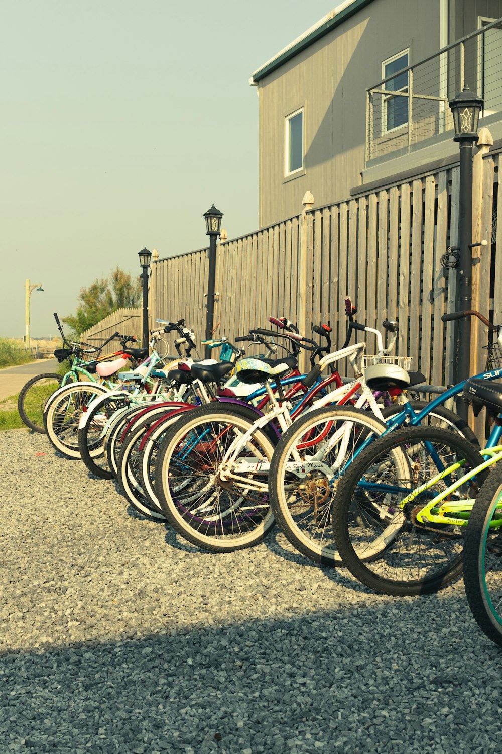 a row of bikes parked next to a fence