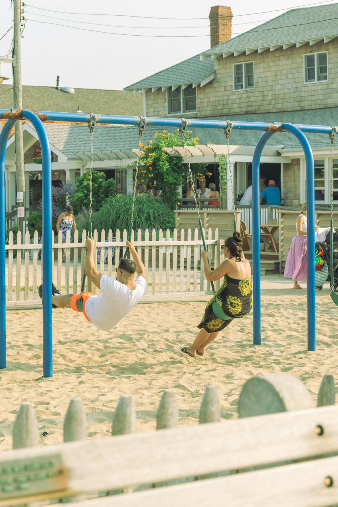 girl in yellow shirt and white pants jumping on blue metal frame