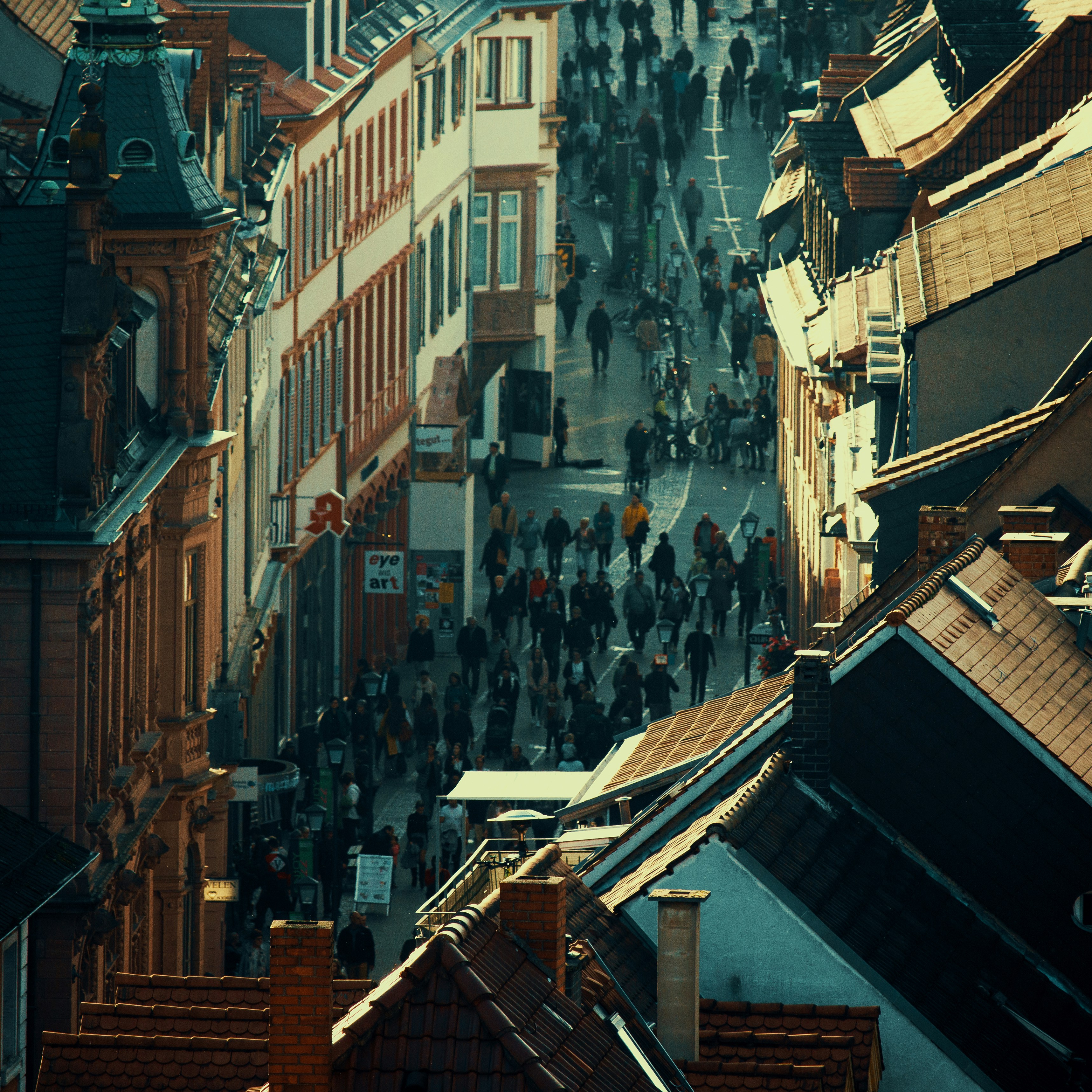 people walking on street between high rise buildings during daytime