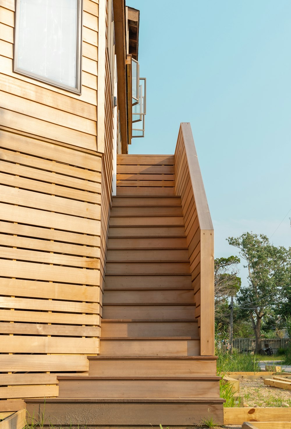 brown wooden staircase near green trees during daytime