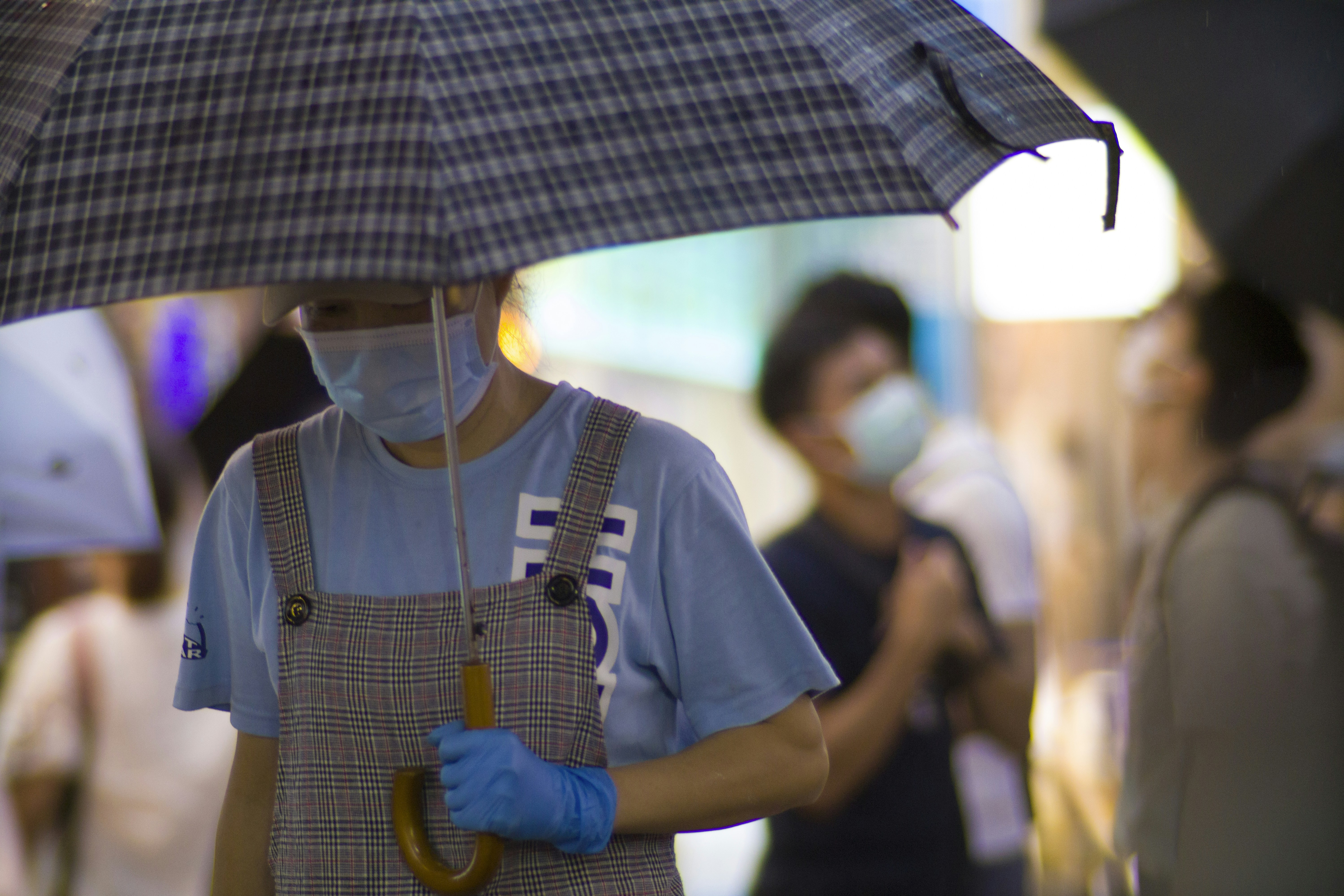 man in black crew neck t-shirt holding umbrella
