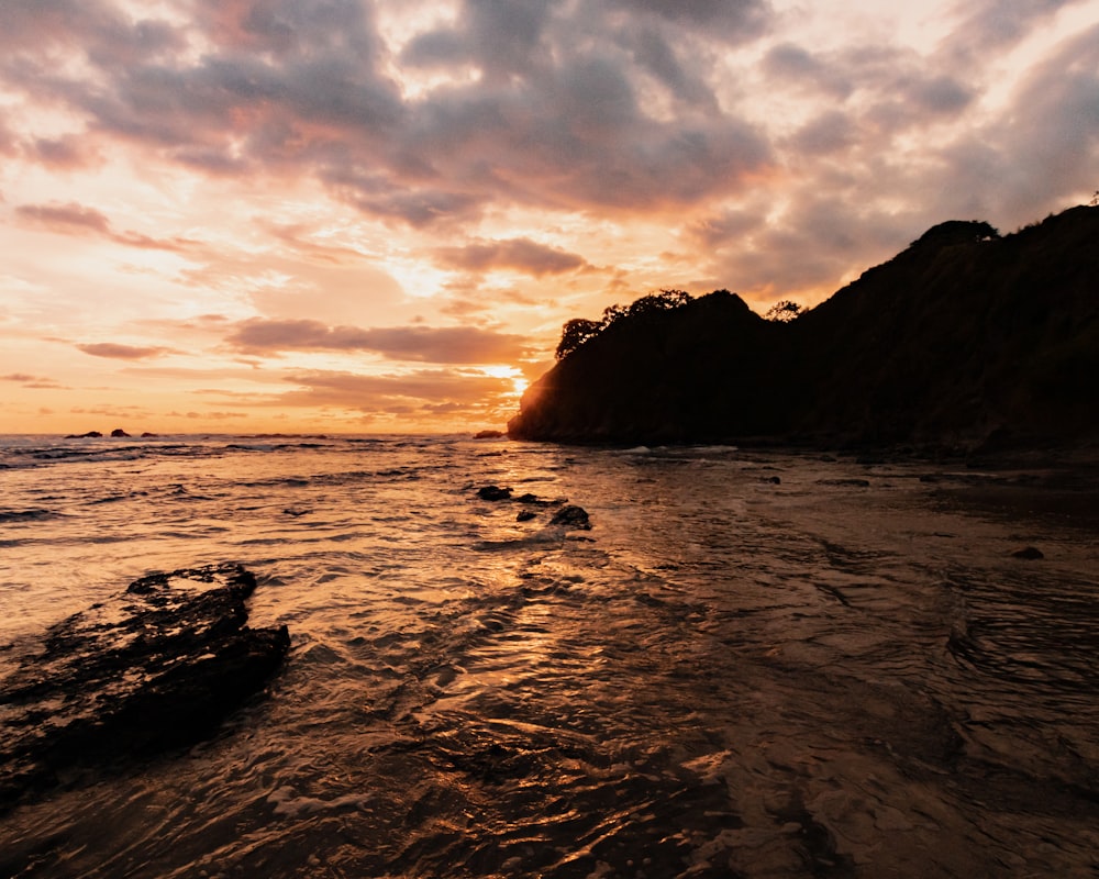 sea waves crashing on shore during sunset