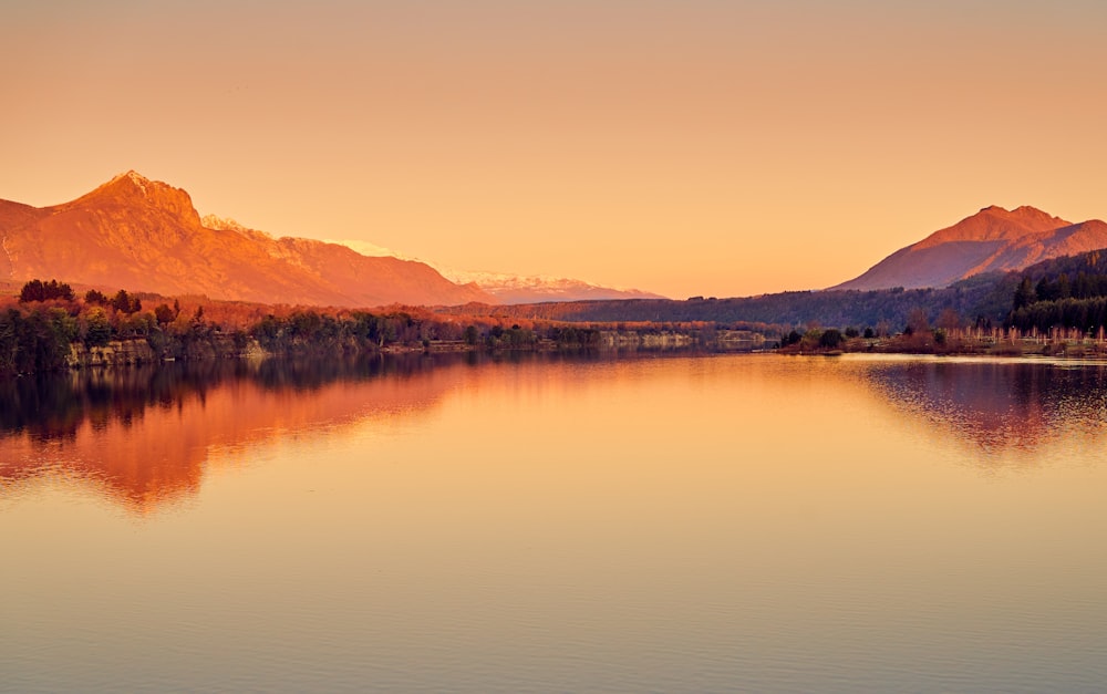 body of water near mountain during daytime