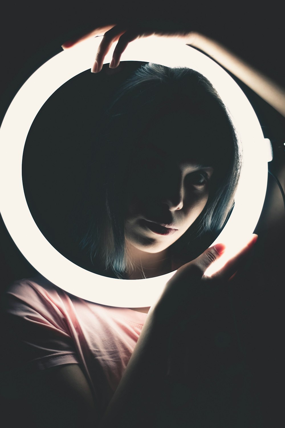 woman in red shirt holding round mirror