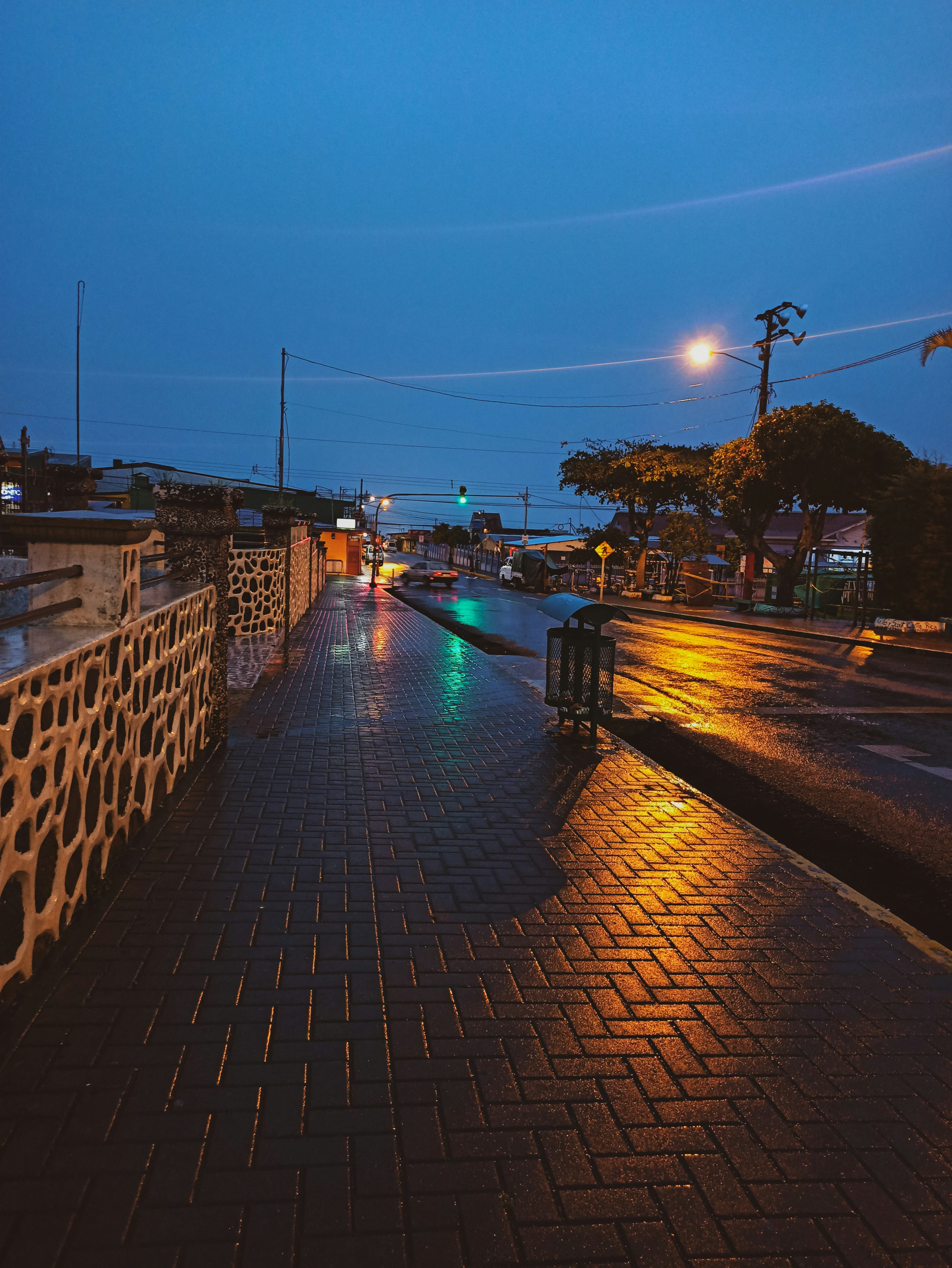 Moody dark photography, atmospheric urban lighting at night, reflective wet streets, cinematic editorial aesthetic