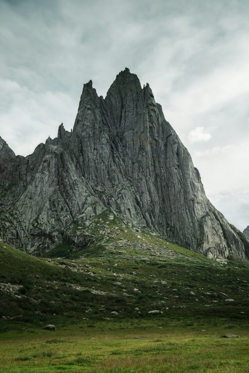 gray rocky mountain under cloudy sky during daytime