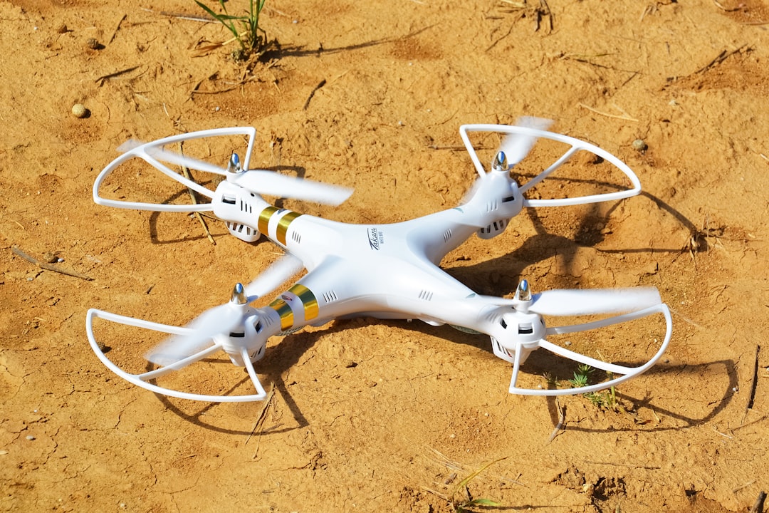 white and yellow drone on brown sand during daytime