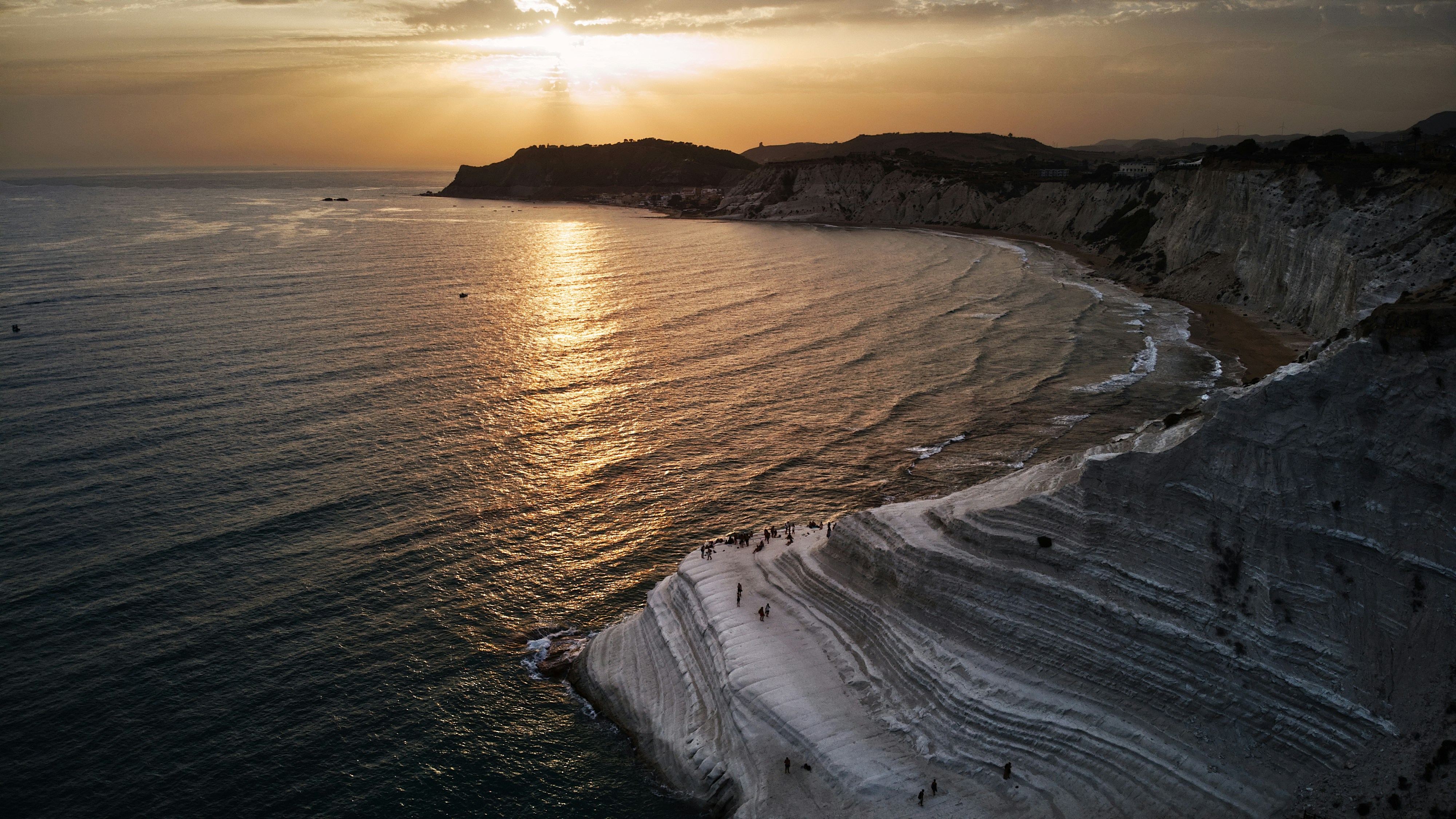 ocean waves crashing on shore during sunset