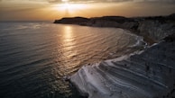 ocean waves crashing on shore during sunset