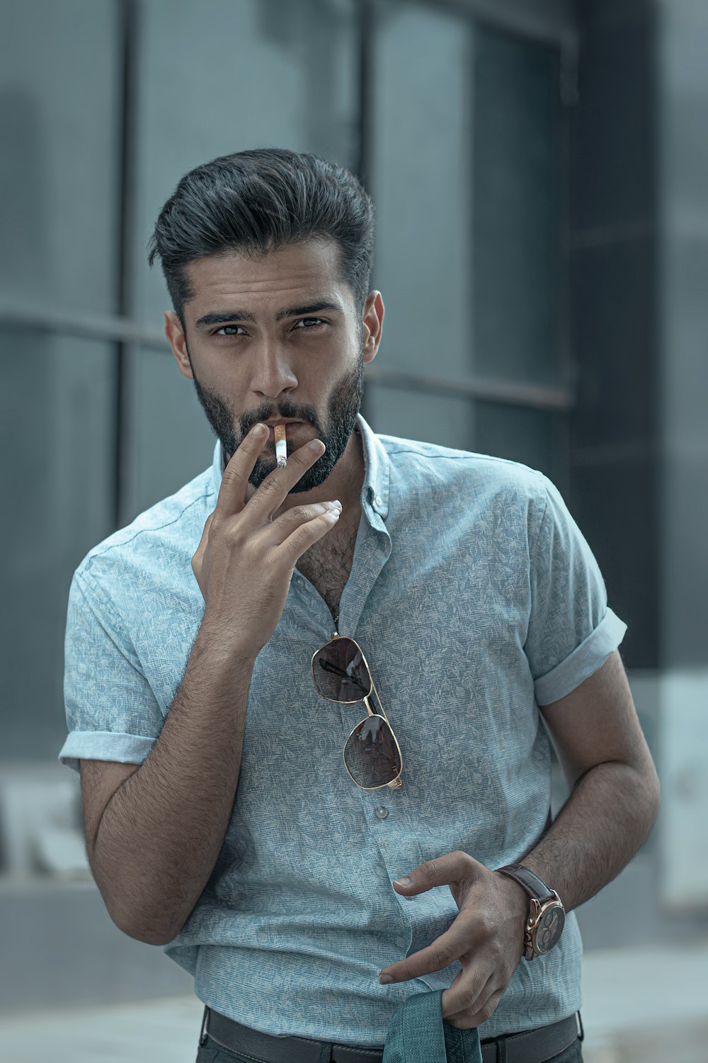 homme en t-shirt bleu à col rond portant des lunettes de soleil aviateur