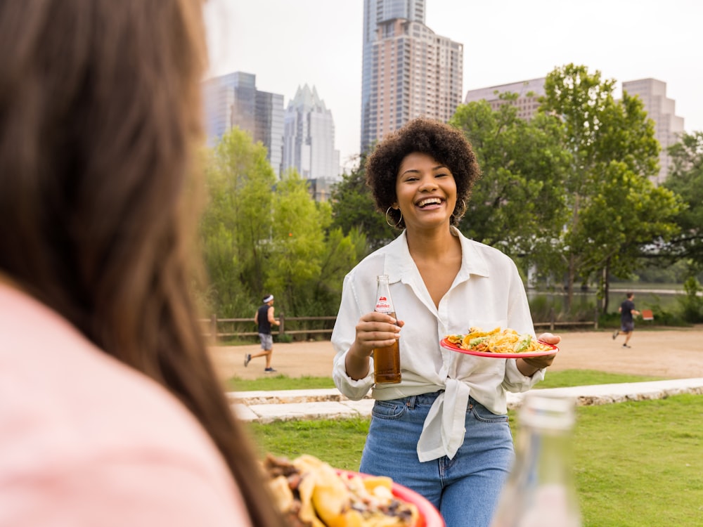 ハンバーガーとフライドポテトのトレイを持つ白いブレザーの女性