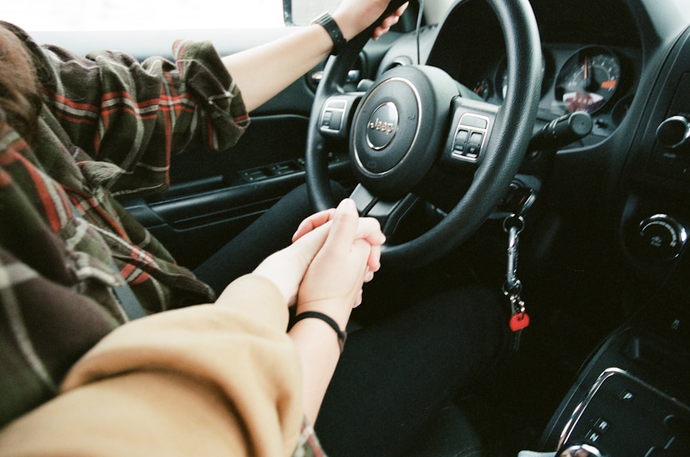 person in beige long sleeve shirt driving car