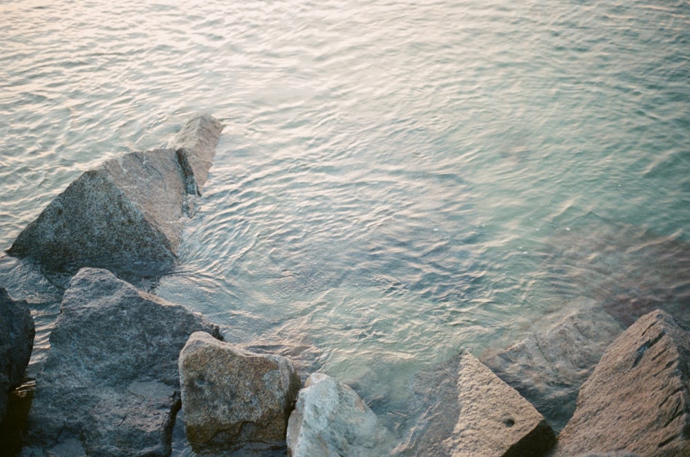 gray rock formation beside body of water during daytime