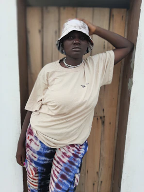 A model wearing comfortable beige daily wear essentials, seated casually.