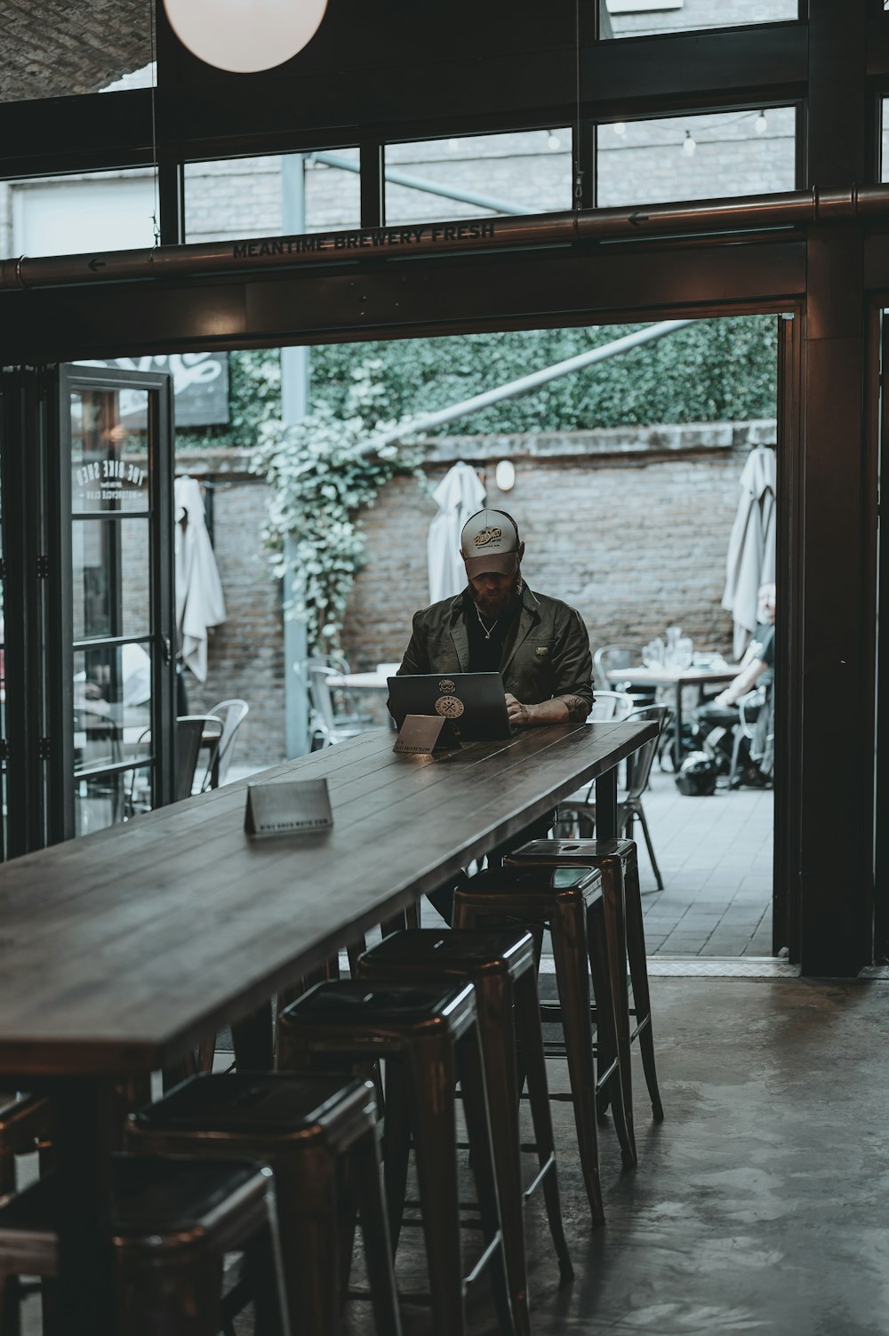 man in black jacket sitting on chair near table