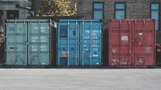 blue steel container van on gray asphalt road during daytime