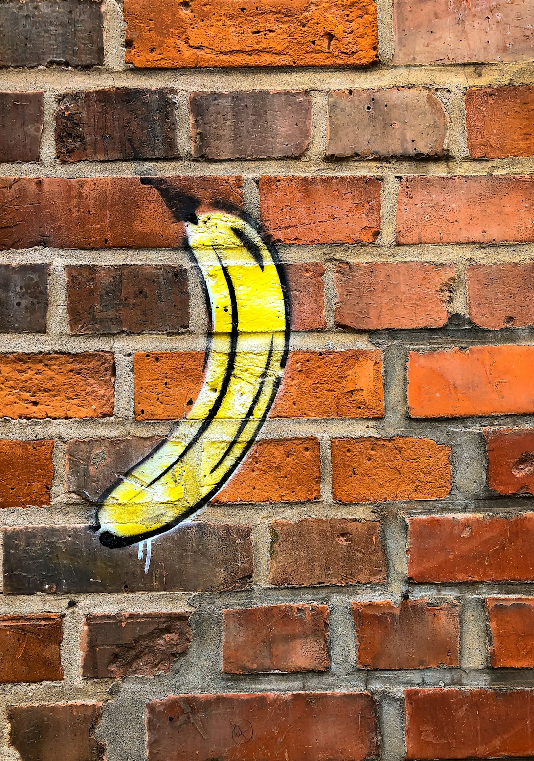 yellow and black surfboard on brown brick wall
