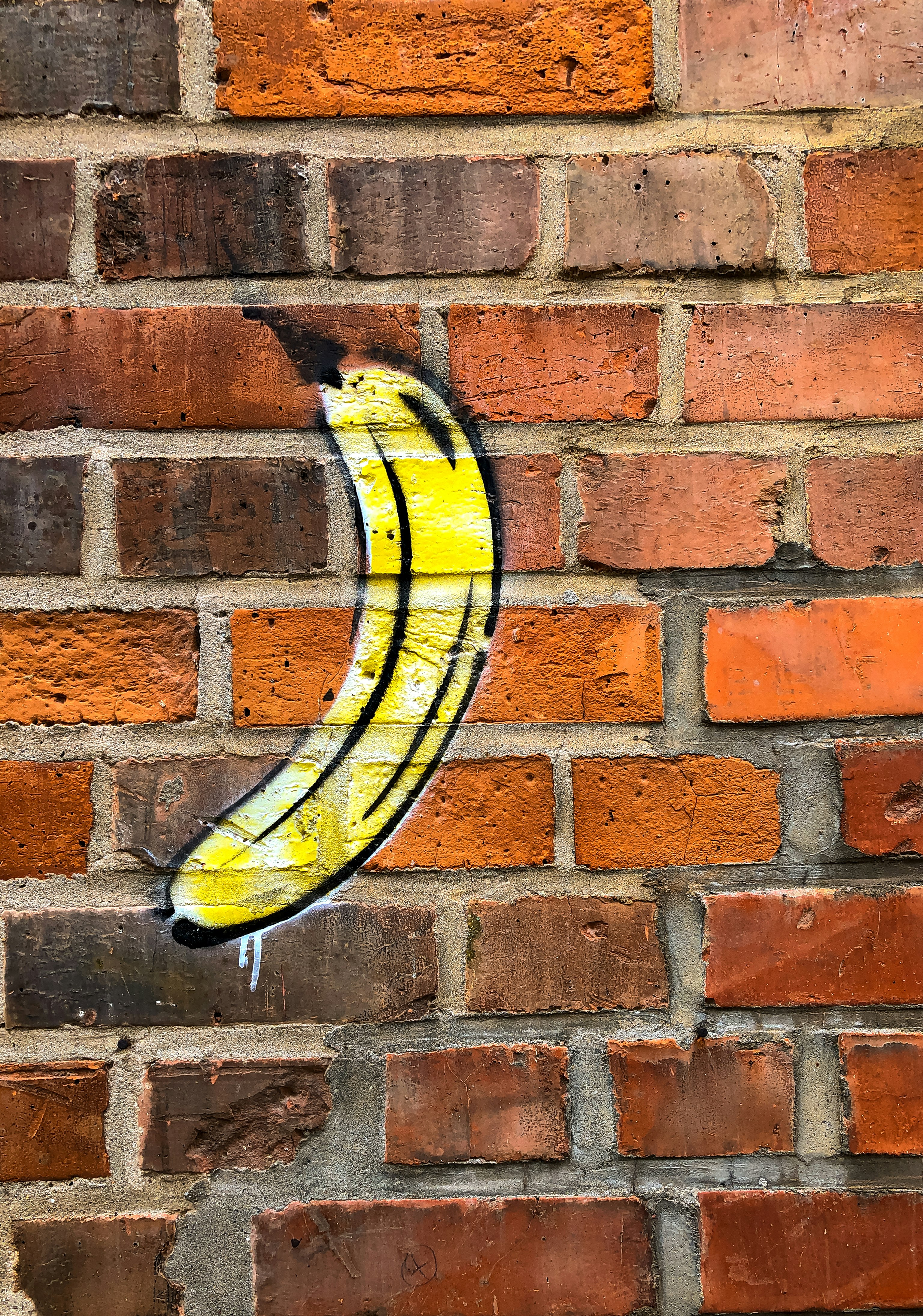 yellow and black surfboard on brown brick wall