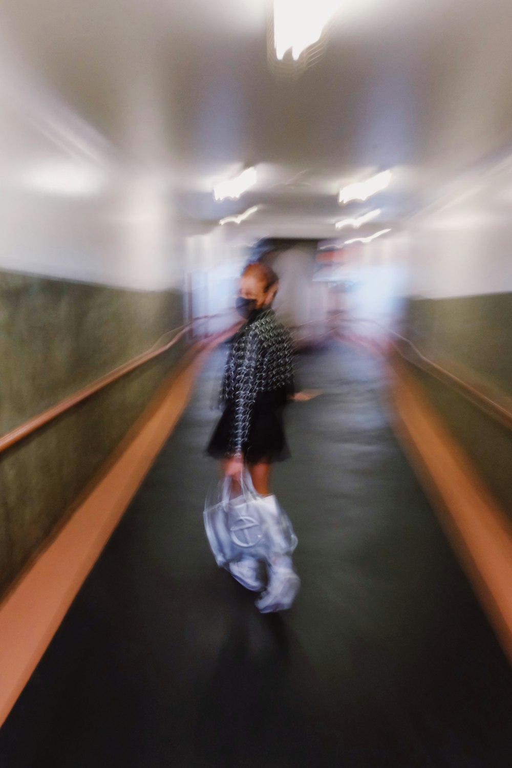 man in black and white checkered dress shirt walking on hallway