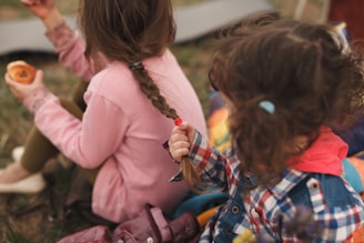 girl in pink jacket sitting on bench