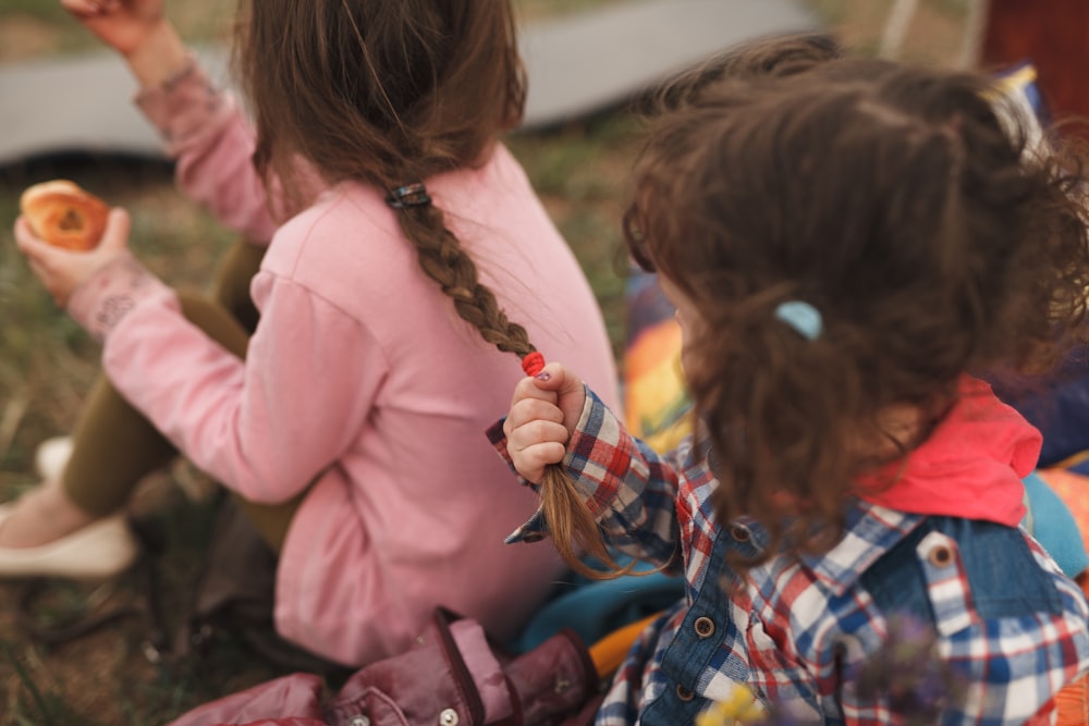 girl in pink jacket sitting on bench