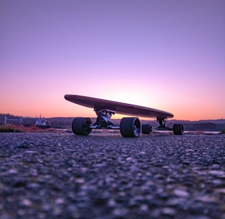 black longboard on gray concrete ground during sunset