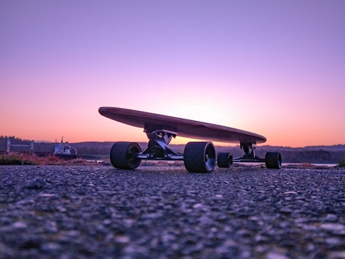 black longboard on gray concrete ground during sunset