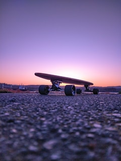 black longboard on gray concrete ground during sunset