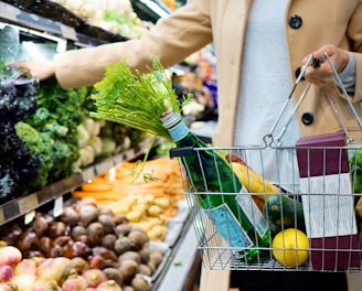 woman in white coat holding green shopping cart