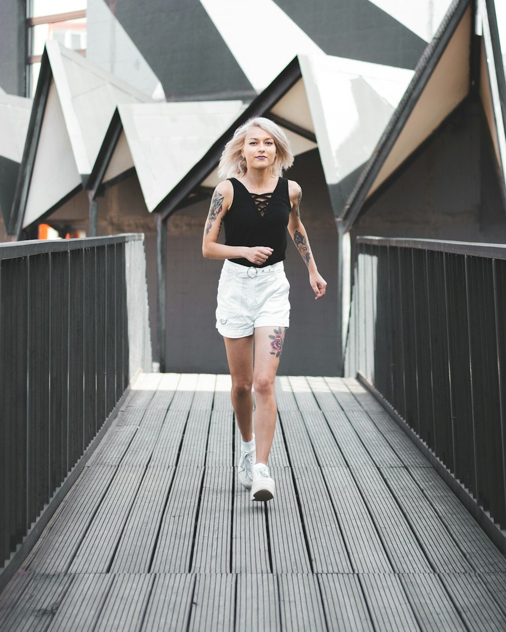 woman in black tank top and blue denim shorts standing on wooden floor