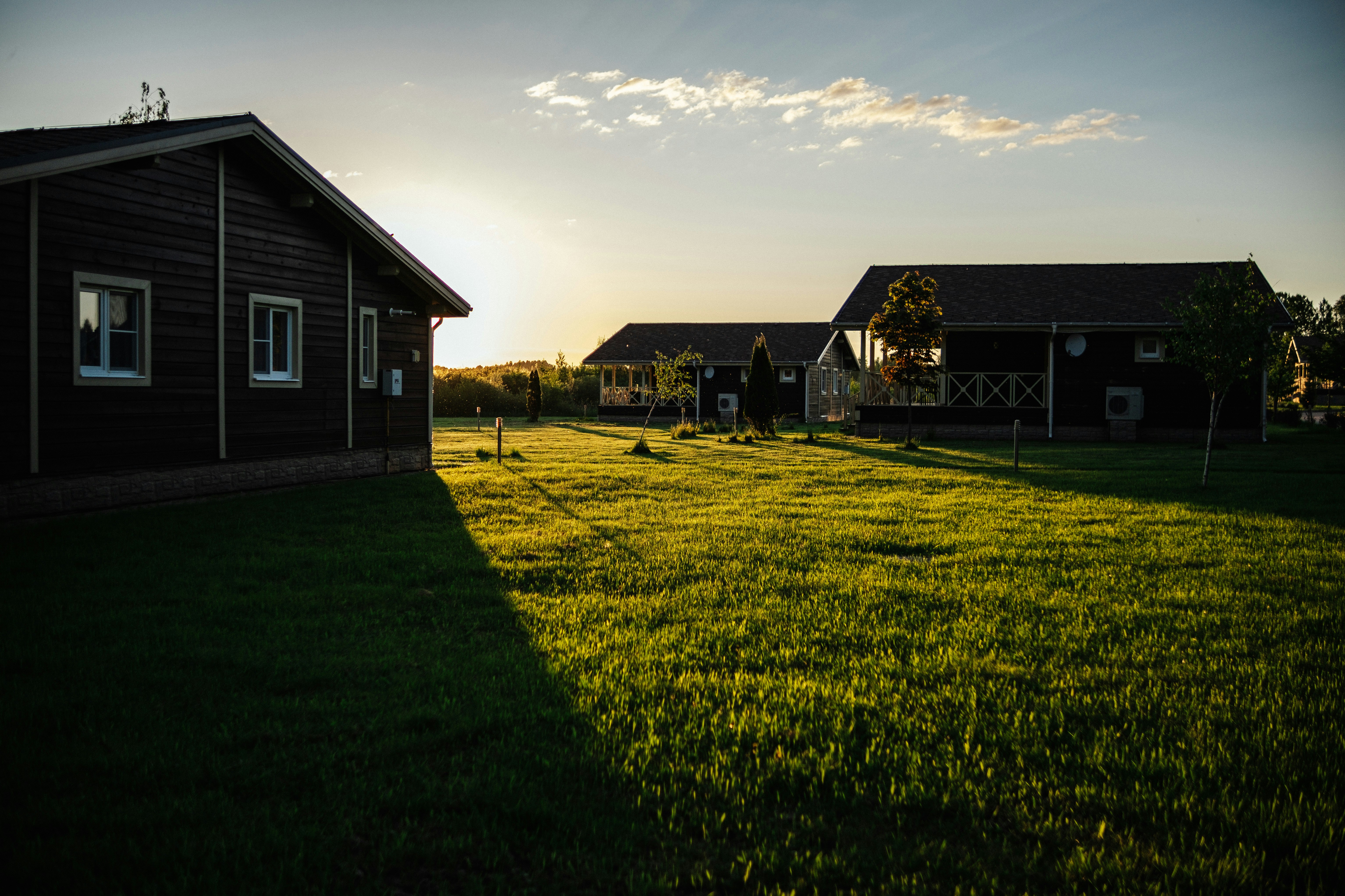 black and white house on green grass field under white clouds and blue sky during daytime